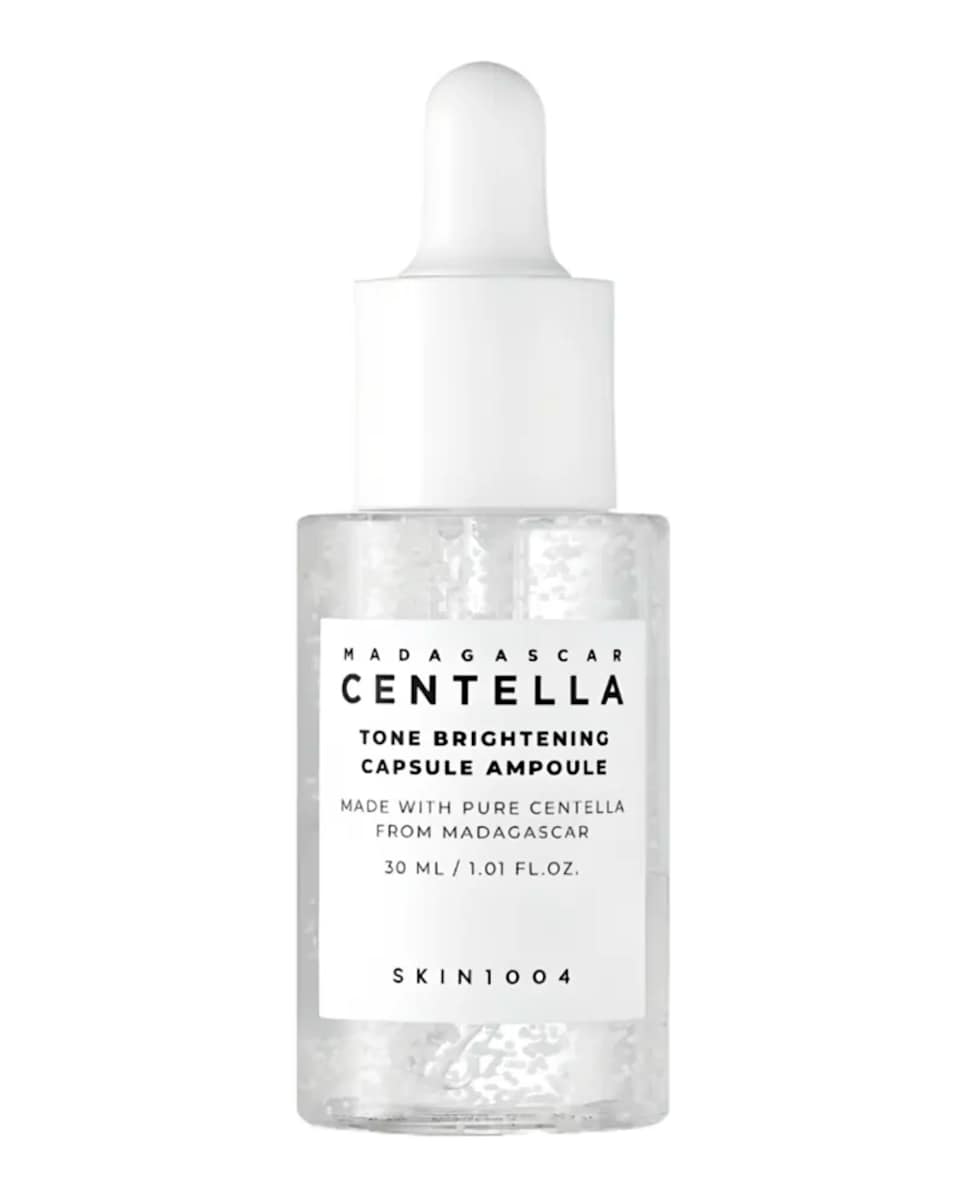 Ampolla facial iluminadora con centella asiática de SKIN1004, en un frasco transparente con gotero blanco.